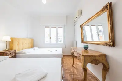 a room with two beds and a mirror on the wall at Victoria Supreme Suite in Athens