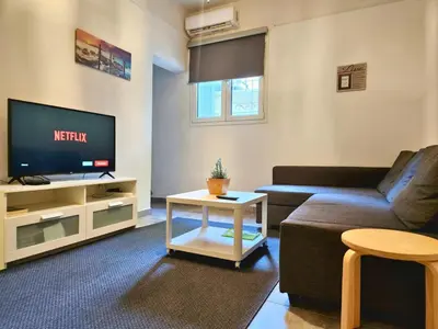 a living room with a couch and a tv at Lycabettus Edge in Athens