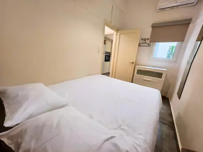 a white bed in a small room with a window at Lycabettus Edge in Athens