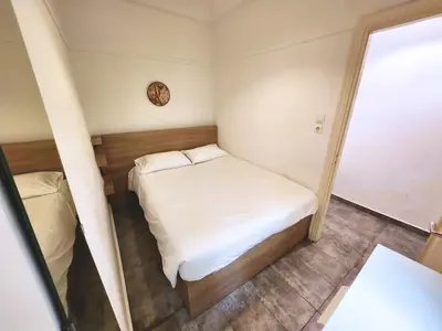 a small room with a bed and a clock on the wall at Lycabettus Edge in Athens