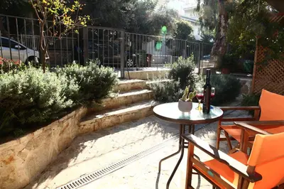 a patio with a table and chairs and a fence at Nefeli in Athens