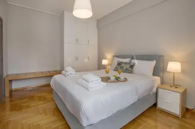 a bedroom with a large white bed with towels on it at Cozy apartment in Syntagma-Plaka by GHH in Athens