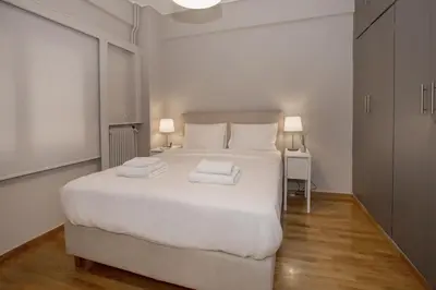 a bedroom with a white bed with two towels on it at Cozy apartment in Syntagma-Plaka by GHH in Athens