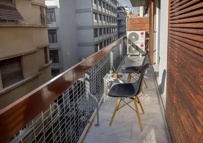 a balcony with two chairs and a table on it at Cozy apartment in Syntagma-Plaka by GHH in Athens