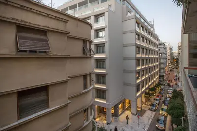 a tall white building with cars parked on a street at Cozy apartment in Syntagma-Plaka by GHH in Athens