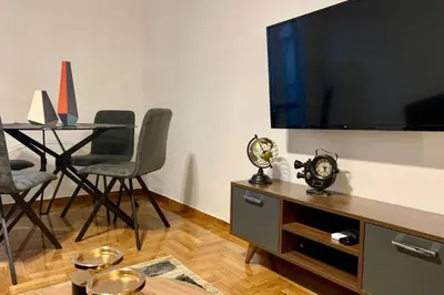 a living room with a tv and a table with chairs at Kallimarmaro 2-Bedroom Apartment in Athens