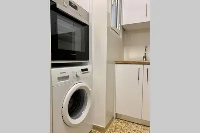 a kitchen with a washing machine and a tv at Kallimarmaro 2-Bedroom Apartment in Athens