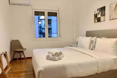 a bedroom with a white bed with towels on it at Kallimarmaro 2-Bedroom Apartment in Athens