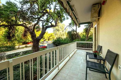 a balcony with two chairs and a tree at Boutique77 Luxury Apartment in Athens