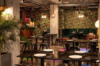 a restaurant with tables and chairs and floral wallpaper at Max Brown Hotel Downtown Part of Sircle Collection Formally known as Dave Red in Athens