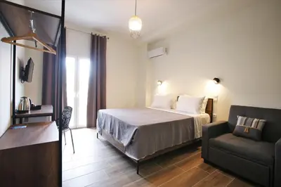 a hotel room with a bed and a couch at Aethon Airport Project-FREE SHUTTLE by GK Properties in Markopoulo