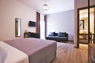 a bedroom with a bed and a couch at Aethon Airport Project-FREE SHUTTLE by GK Properties in Markopoulo