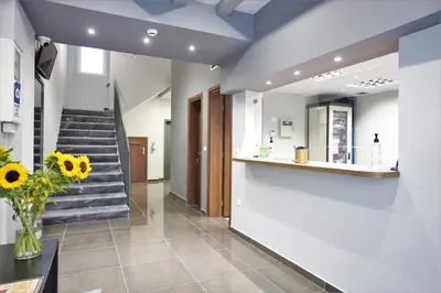 a lobby with a staircase and a vase of flowers at Aethon Airport Project-FREE SHUTTLE by GK Properties in Markopoulo