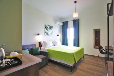 a hotel room with a bed and a couch at Aethon Airport Project-FREE SHUTTLE by GK Properties in Markopoulo