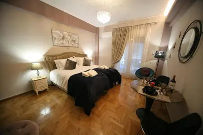 a bedroom with a large bed and a table at Denise Luxury Apartment-Centre of Athens,Kolonaki in Athens