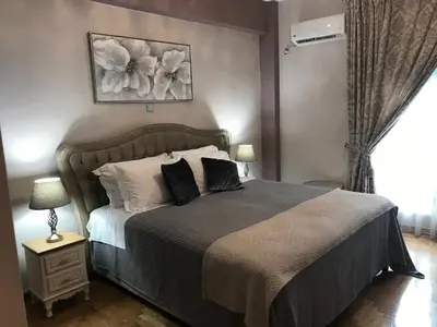 a bedroom with a large bed and a window at Denise Luxury Apartment-Centre of Athens,Kolonaki in Athens