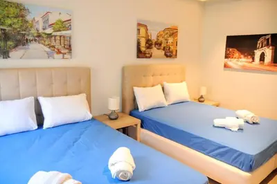 two beds in a room with blue sheets at Luxurious apartment in Acropolis in Athens