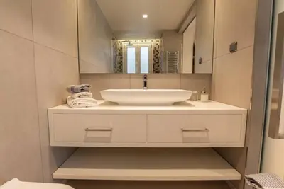 a bathroom with a white sink and a mirror at Luxurious apartment in Acropolis in Athens