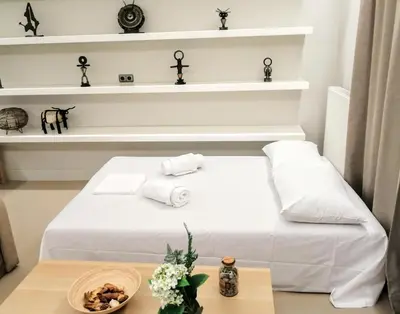 a room with a white bed with white shelves at Luxurious minimal apartment in Acropolis in Athens