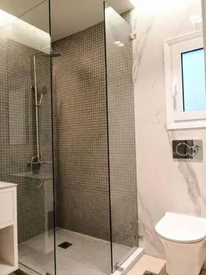 a bathroom with a glass shower with a toilet at Luxurious minimal apartment in Acropolis in Athens
