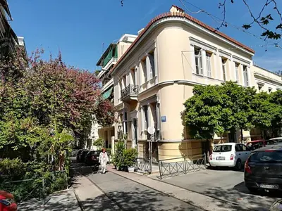 a person walking down a street in front of a building at Luxurious minimal apartment in Acropolis in Athens