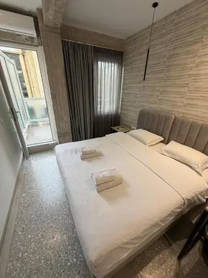 a large bed in a room with a large window at athensdot in Athens