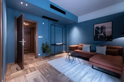 a living room with blue walls and a couch at The H Experience Boutique Apartments Athens - free parking and fiber internet in Athens