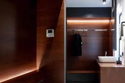 a bathroom with a sink and a wooden wall at The H Experience Boutique Apartments Athens - free parking and fiber internet in Athens