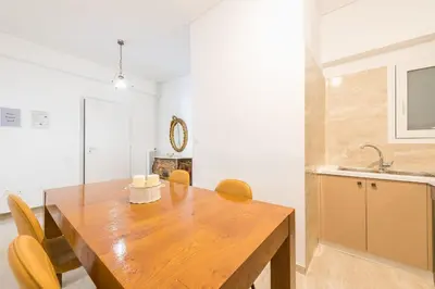a kitchen and dining room with a wooden table and chairs at Victoria Diamond Suites Apartments in Athens