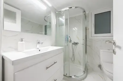 a white bathroom with a sink and a shower at Victoria Diamond Suites Apartments in Athens