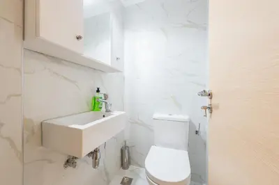 a white bathroom with a toilet and a sink at Victoria Diamond Suites Apartments in Athens