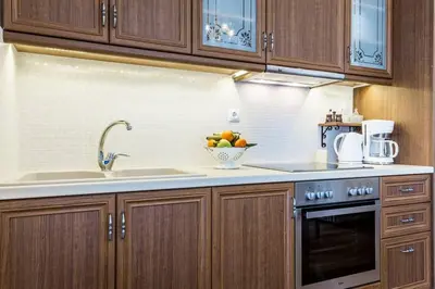 a kitchen with wooden cabinets and a bowl of fruit at Neoclassical apartment with 3 bedrooms in Piraeus in Piraeus