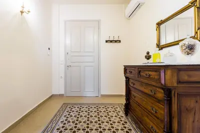 a room with a dresser and a mirror and a door at Neoclassical apartment with 3 bedrooms in Piraeus in Piraeus