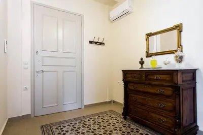 a room with a door and a dresser and a mirror at Neoclassical apartment with 3 bedrooms in Piraeus in Piraeus