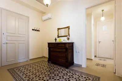 a room with a dresser and a mirror and a door at Neoclassical apartment with 3 bedrooms in Piraeus in Piraeus
