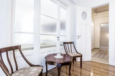 a room with two chairs and a table and a lamp at Neoclassical apartment with 3 bedrooms in Piraeus in Piraeus