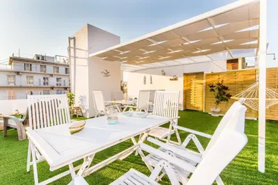 a patio with a white table and chairs on the grass at Neoclassical apartment with 2 bedrooms in Piraeus in Piraeus