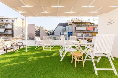 a balcony with white chairs and a table and grass at Neoclassical apartment with 2 bedrooms in Piraeus in Piraeus