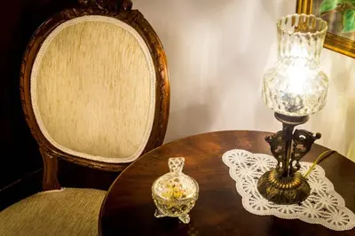 a table with a lamp and a glass vase on it at Neoclassical apartment with 2 bedrooms in Piraeus in Piraeus