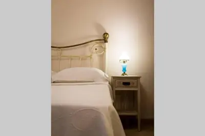 a bedroom with a bed and a lamp on a nightstand at Neoclassical apartment with 2 bedrooms in Piraeus in Piraeus