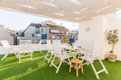 a balcony with white chairs and a table on grass at Neoclassical flat with 2 bedrooms in Piraeus in Piraeus