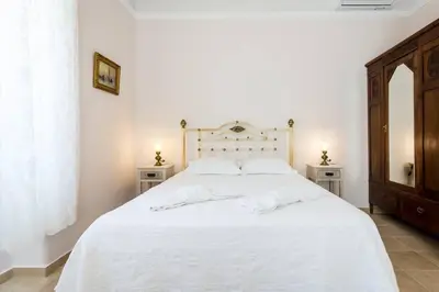 a bedroom with a white bed with two night stands at Neoclassical flat with 2 bedrooms in Piraeus in Piraeus