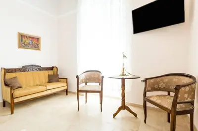 a living room with a couch and a table and chairs at Neoclassical flat with 2 bedrooms in Piraeus in Piraeus