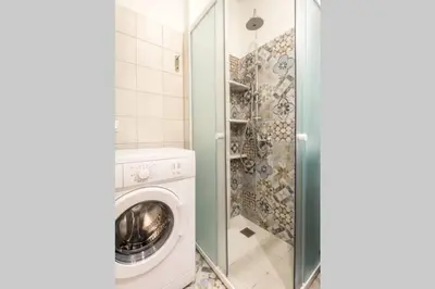 a bathroom with a washing machine and a shower at Neoclassical flat with 2 bedrooms in Piraeus in Piraeus