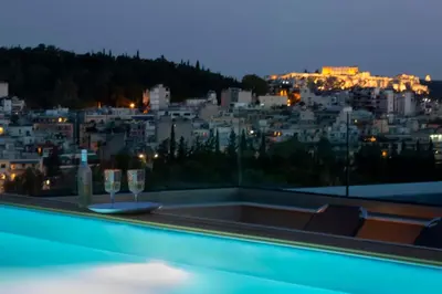 a swimming pool with two wine glasses and a city at Athens Panorama Project in Athens