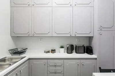 a kitchen with white cabinets and a sink at Deluxe & Stylish 2BD Apartment in Pangrati by UPSTREET in Athens