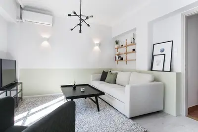 a living room with a white couch and a table at Deluxe & Stylish 2BD Apartment in Pangrati by UPSTREET in Athens