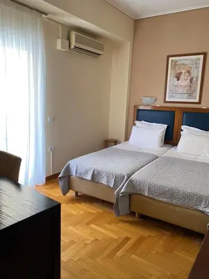 a bedroom with two beds and a window at Adams Hotel in Athens