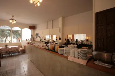 a restaurant with a counter with plates on it at Adams Hotel in Athens