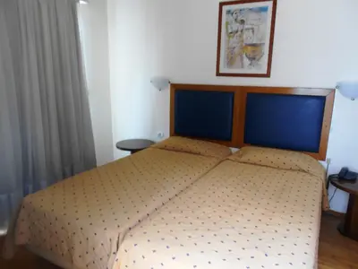 a bedroom with a large bed with a wooden headboard at Adams Hotel in Athens